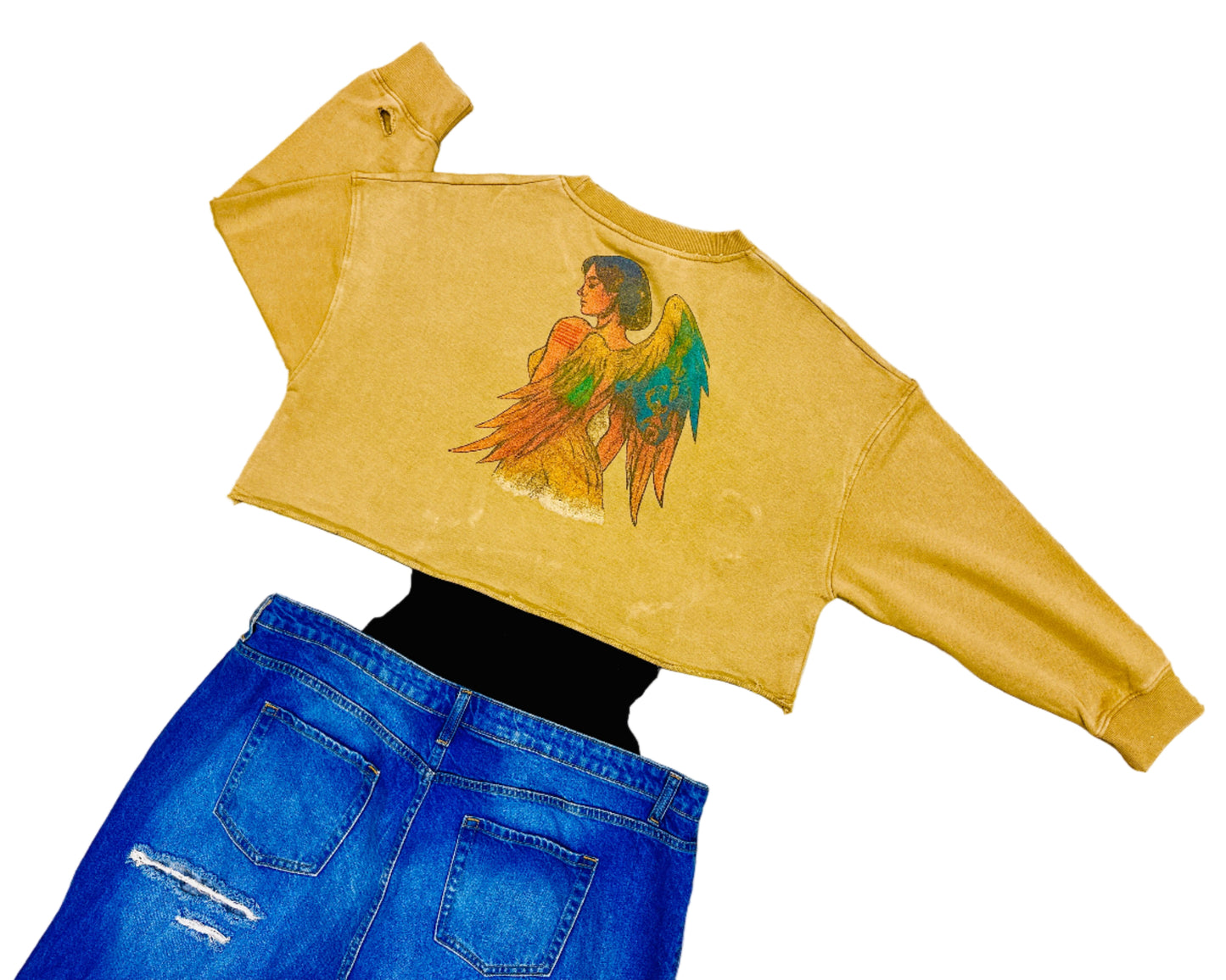 Beige sweatshirt with angel graphic and blue jeans on a textured surface